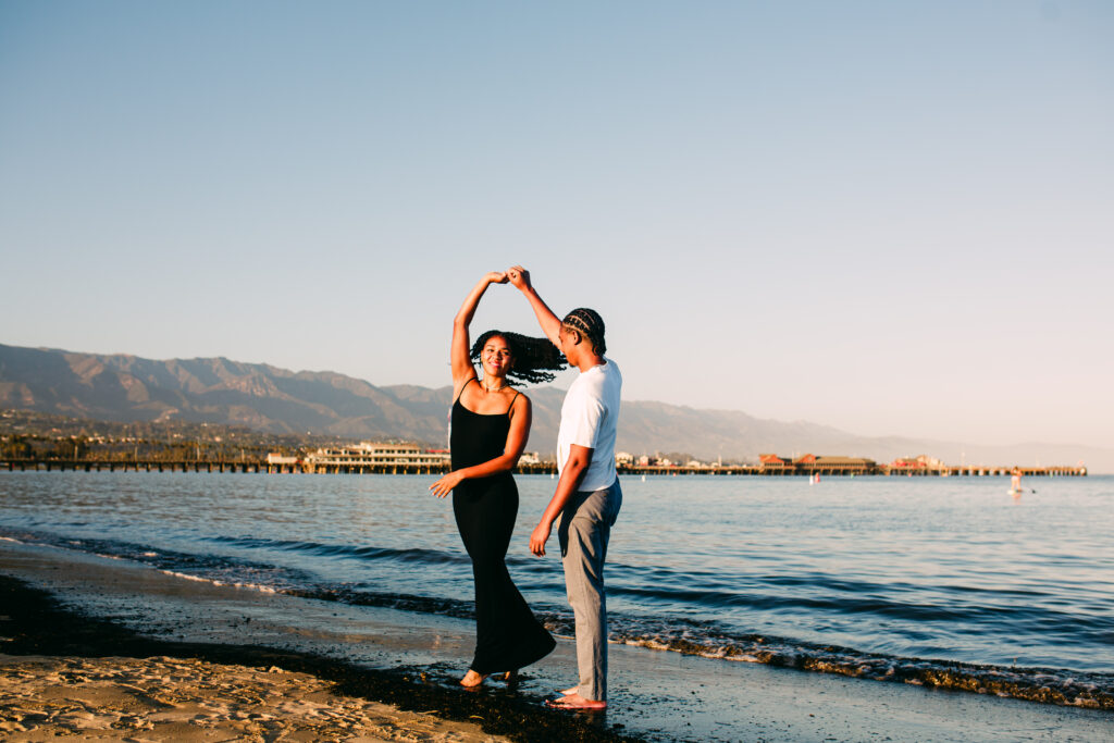 Dancing: Couple dancing at the water's edge during a golden hour Santa Barbara beach engagement session