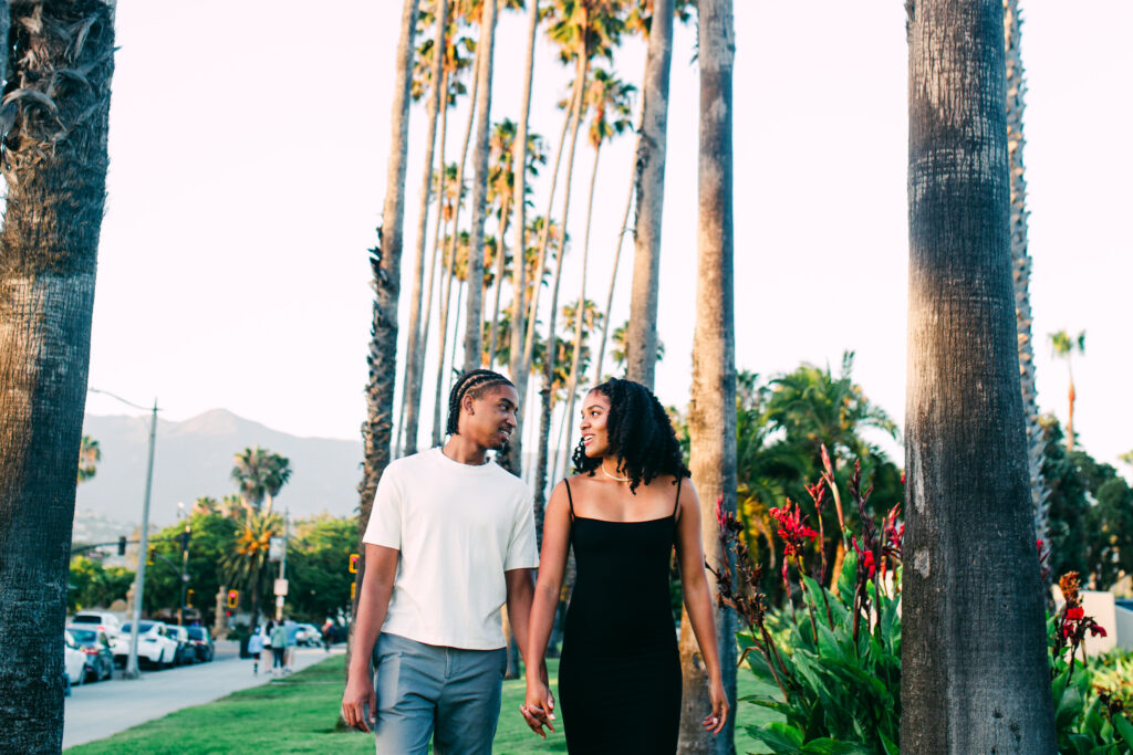 Palm strip, embracing: Couple laughing together on the lawn near the Santa Barbara skatepark during their engagement session